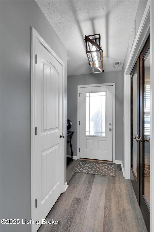 foyer entrance featuring dark wood-type flooring and a textured ceiling