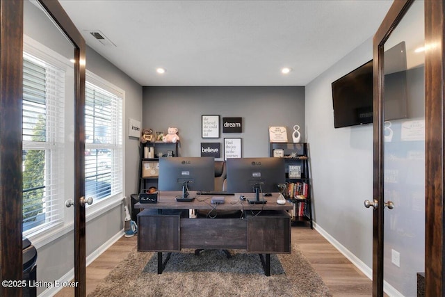 office area with light hardwood / wood-style floors and french doors