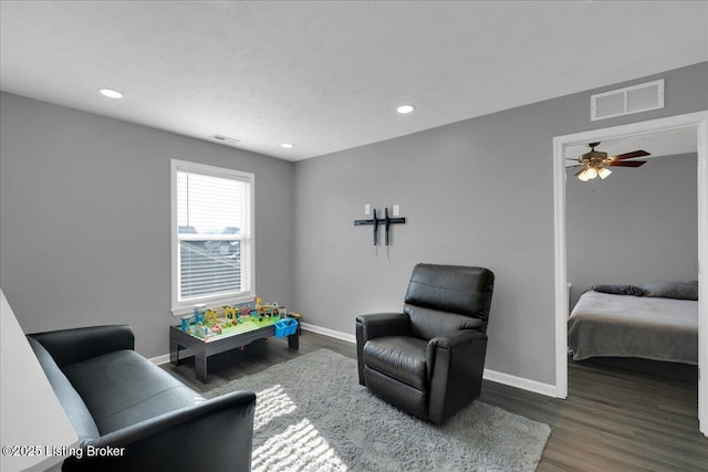 living area with dark hardwood / wood-style floors and ceiling fan