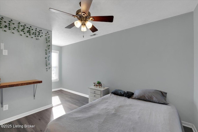 bedroom with ceiling fan and dark hardwood / wood-style floors