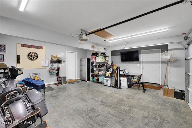 garage featuring a garage door opener and stainless steel refrigerator