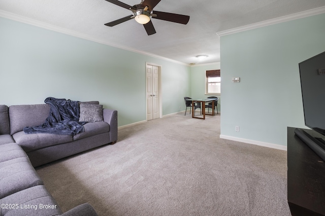 living room with ornamental molding, carpet, ceiling fan, and baseboards