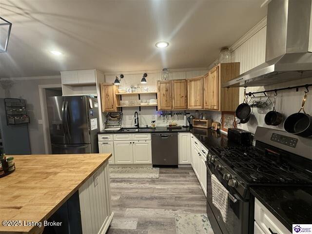 kitchen featuring fridge with ice dispenser, wall chimney exhaust hood, dishwashing machine, gas range, and sink