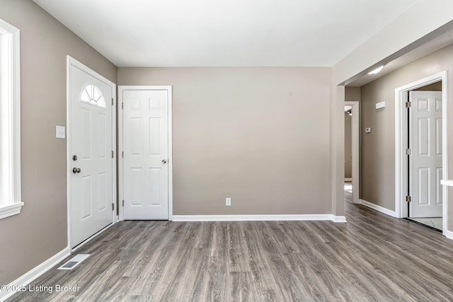 entrance foyer with dark wood-style floors, baseboards, and visible vents