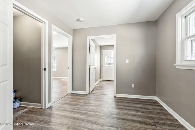 interior space with a wealth of natural light, baseboards, and wood finished floors