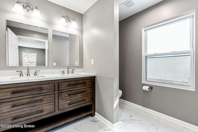 full bathroom with marble finish floor, baseboards, visible vents, and a sink