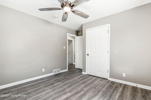 unfurnished bedroom featuring ceiling fan, visible vents, baseboards, and dark wood finished floors