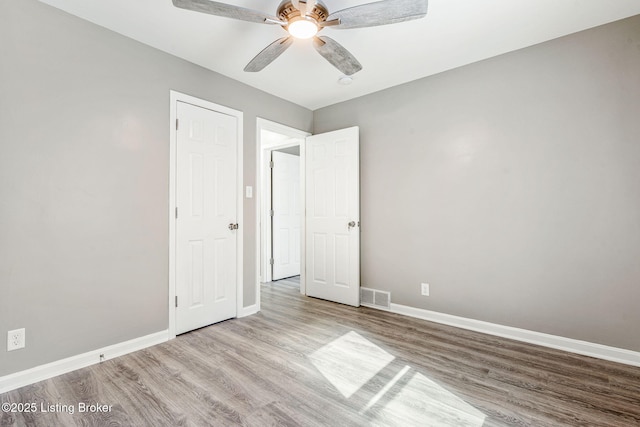 unfurnished bedroom with visible vents, ceiling fan, light wood-style flooring, and baseboards