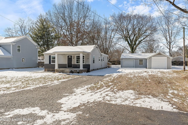 view of front of property with covered porch, a detached garage, and an outdoor structure