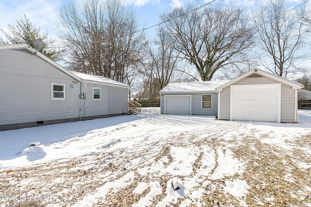 snow covered garage featuring a garage