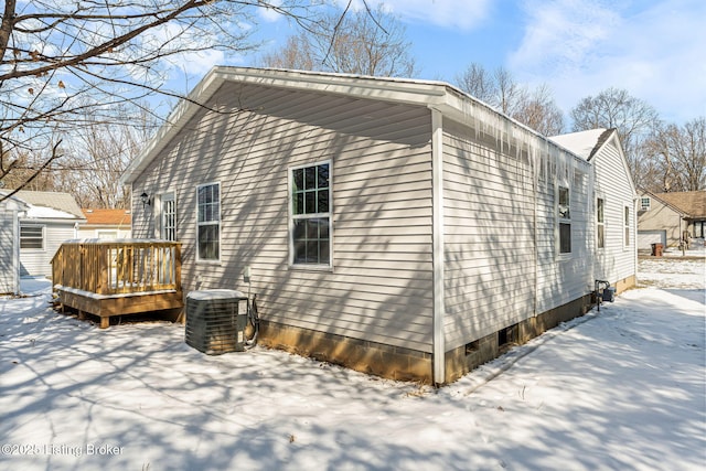 snow covered property featuring a wooden deck and central air condition unit