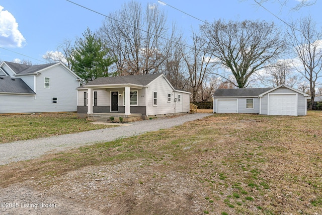 view of front of property featuring an outbuilding, a porch, and a detached garage