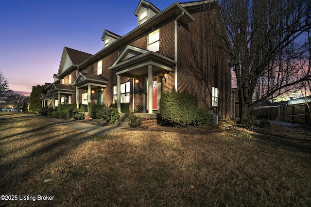 view of front of property featuring brick siding and a front lawn