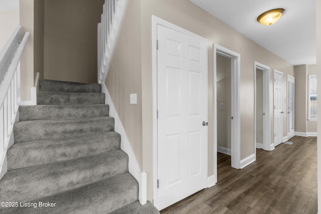 stairway with baseboards and wood finished floors