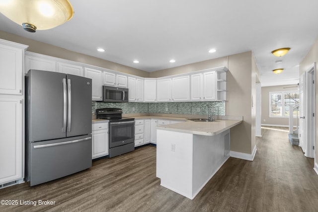 kitchen with stainless steel appliances, white cabinetry, and a peninsula