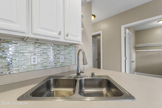 details with light countertops, a sink, white cabinetry, and decorative backsplash