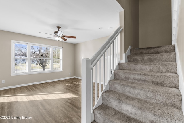 stairway featuring ceiling fan, wood finished floors, and baseboards