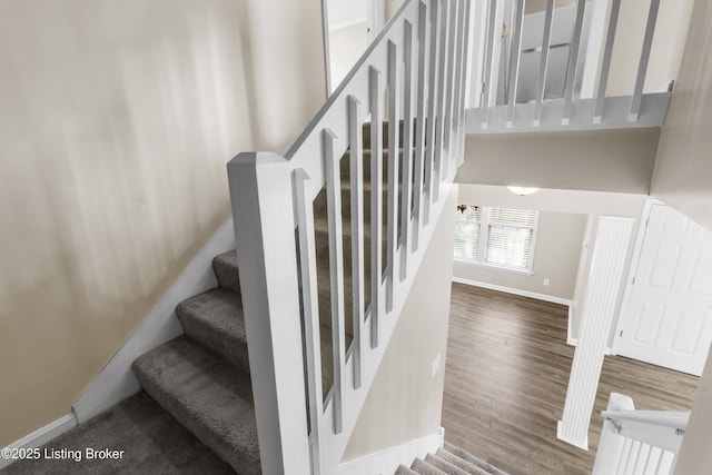 stairway with baseboards and wood finished floors