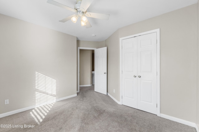 unfurnished bedroom featuring a closet, light colored carpet, ceiling fan, and baseboards