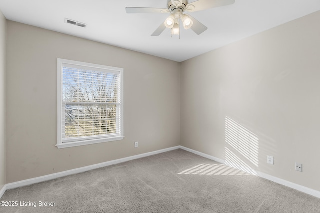 spare room with a ceiling fan, carpet flooring, visible vents, and baseboards