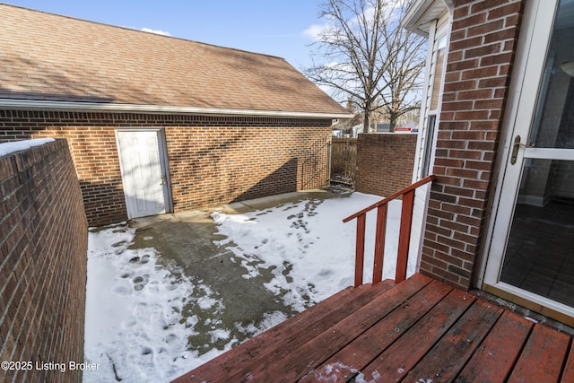 snow covered deck featuring fence