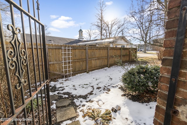 yard covered in snow featuring fence