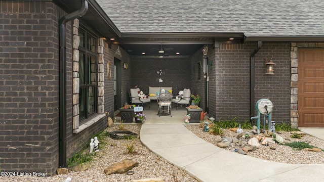 property entrance featuring ceiling fan, a patio, brick siding, and a shingled roof