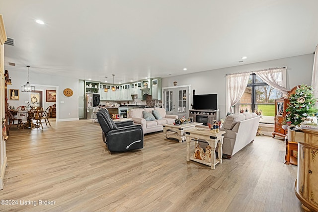 living area with light wood-style floors, recessed lighting, and visible vents