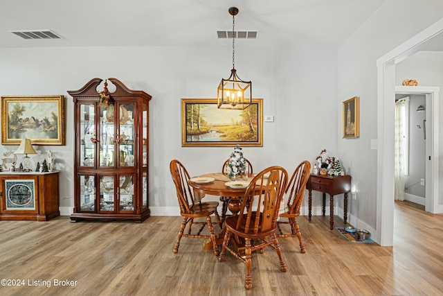 dining room with light wood-type flooring, visible vents, and baseboards