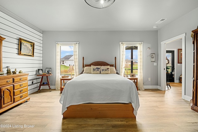 bedroom featuring access to outside, light wood finished floors, and baseboards