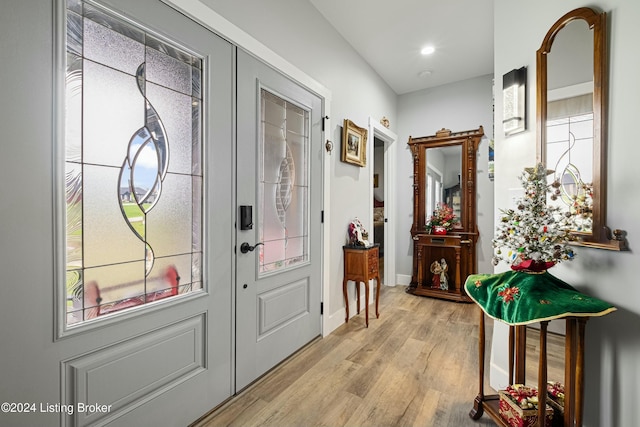 doorway to outside featuring light wood-style floors, plenty of natural light, and baseboards