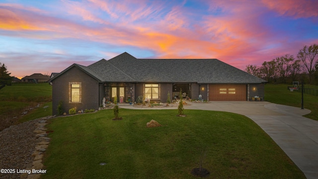 ranch-style home with a garage, driveway, a yard, and a shingled roof