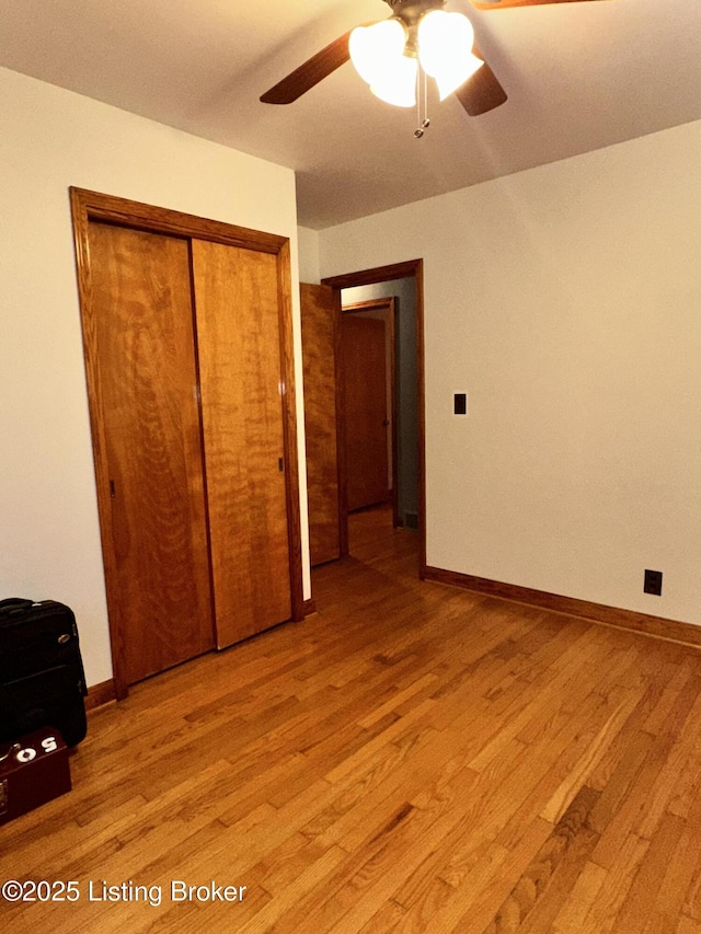 unfurnished bedroom featuring ceiling fan, light hardwood / wood-style floors, and a closet