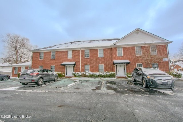 view of front of house featuring uncovered parking and brick siding