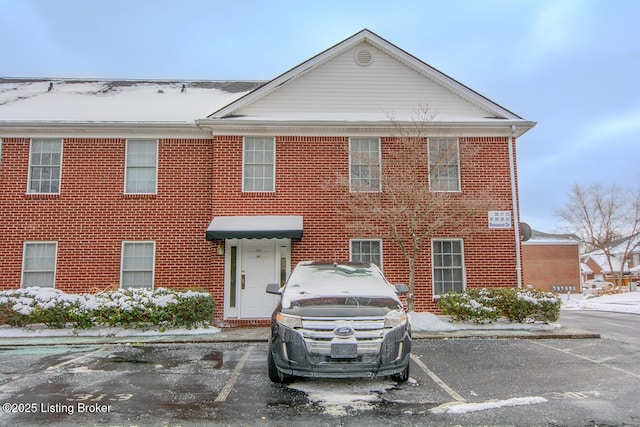 view of front of property featuring uncovered parking and brick siding