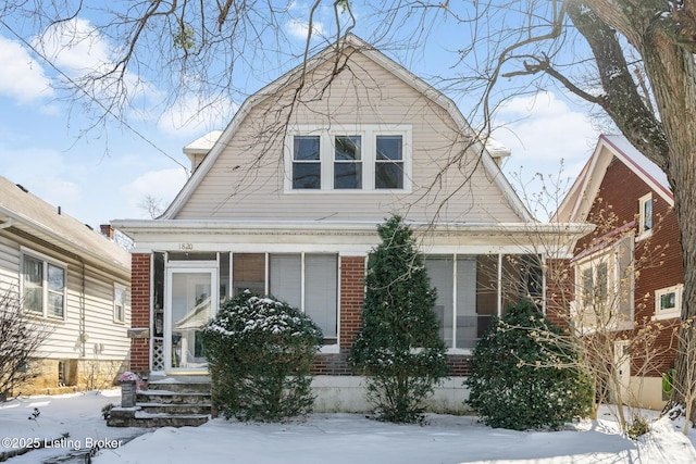 view of front facade featuring brick siding and a gambrel roof