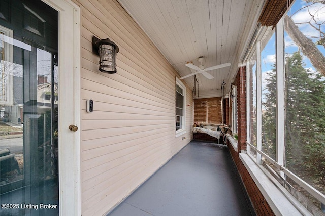 unfurnished sunroom featuring wooden ceiling and ceiling fan