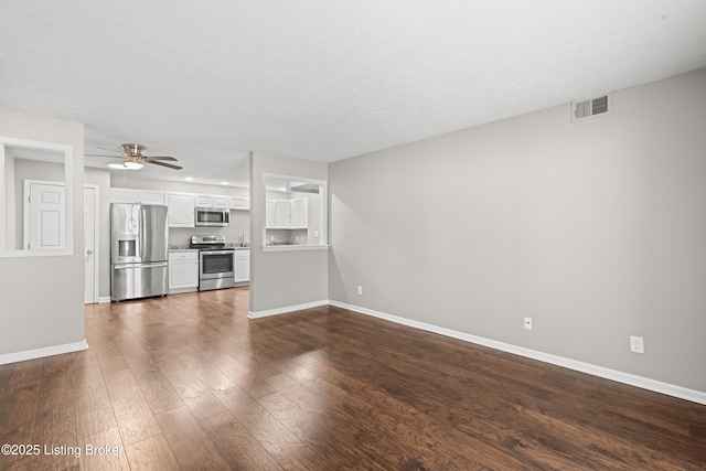 unfurnished living room with dark wood-type flooring and ceiling fan