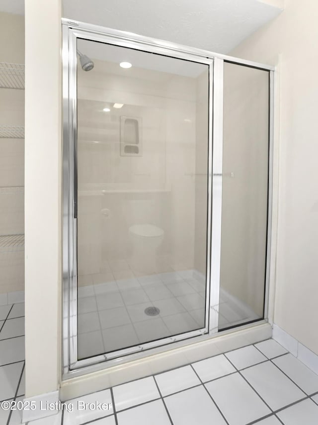 bathroom with tile patterned flooring and a shower with shower door