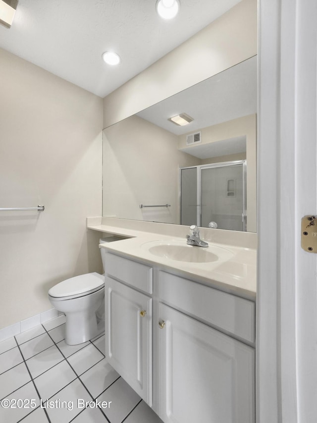 bathroom featuring vanity, a shower with door, toilet, and tile patterned floors