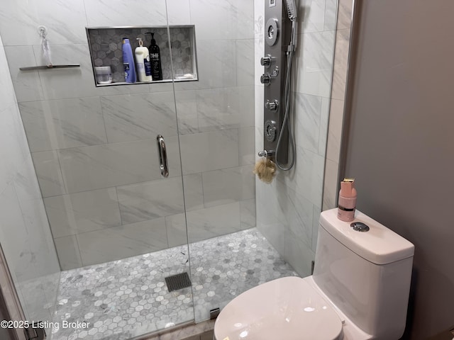 bathroom with toilet and a shower with shower door