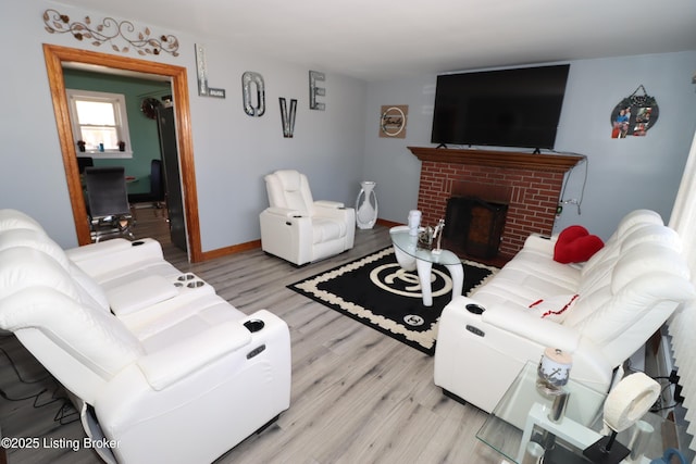 living room with a brick fireplace and light hardwood / wood-style floors