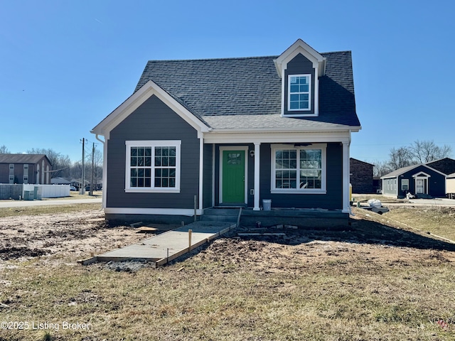 view of front of home with a front yard and roof with shingles