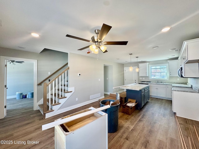 kitchen featuring a kitchen island, white cabinetry, light countertops, and pendant lighting