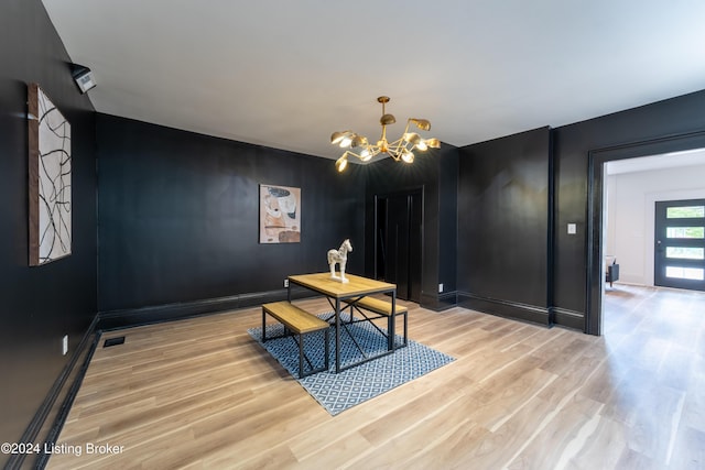 dining area featuring a chandelier, light wood-type flooring, visible vents, and baseboards