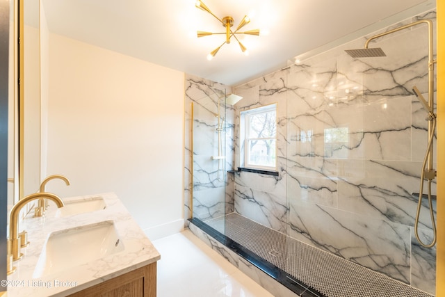 bathroom featuring a sink, a marble finish shower, and double vanity