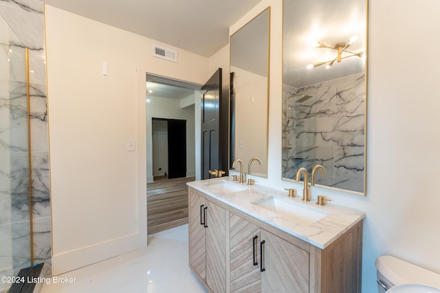 bathroom with visible vents, a sink, toilet, and double vanity