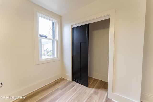 unfurnished bedroom with a closet, light wood-type flooring, and baseboards