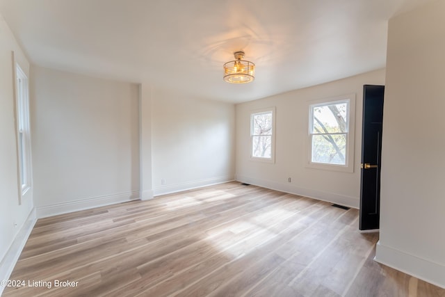 empty room featuring light wood-style flooring and baseboards