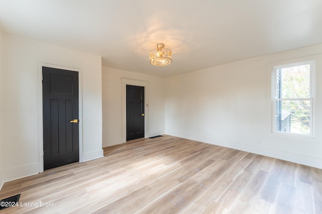 spare room featuring light wood finished floors and baseboards